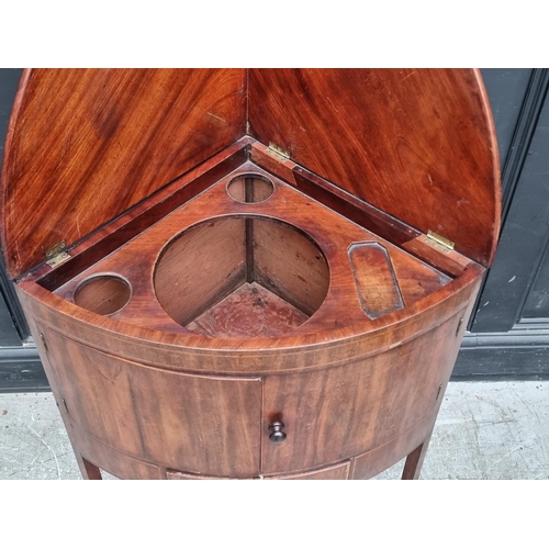 1093 - A George III mahogany corner wash stand, with hinged splashback, 67.5cm wide.