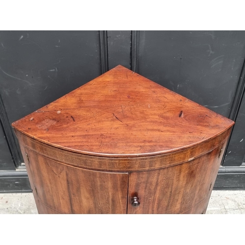 1093 - A George III mahogany corner wash stand, with hinged splashback, 67.5cm wide.