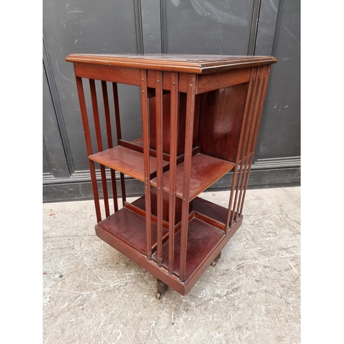 1094 - A late Victorian mahogany, satinwood crossbanded and line inlaid revolving bookcase, with three... 