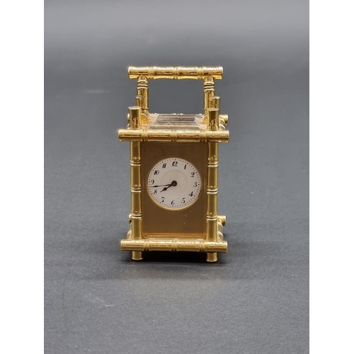 1147 - A small brass simulated bamboo carriage timepiece, height including handle 9.5cm, with winding key.... 