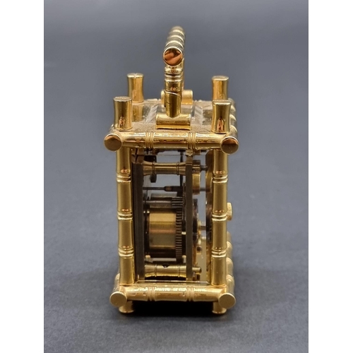 1147 - A small brass simulated bamboo carriage timepiece, height including handle 9.5cm, with winding key.... 