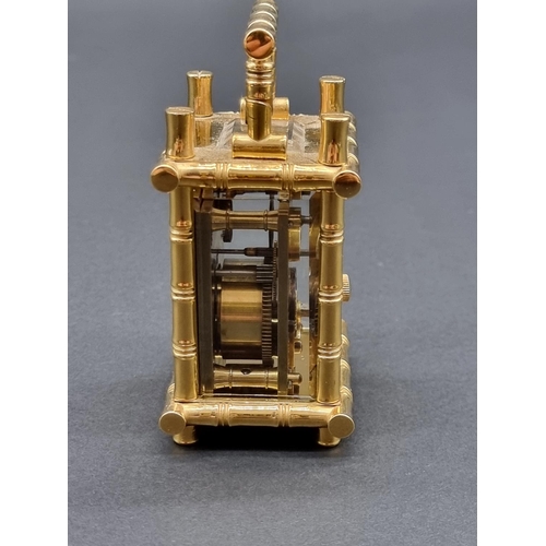 1147 - A small brass simulated bamboo carriage timepiece, height including handle 9.5cm, with winding key.... 