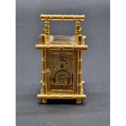 1147 - A small brass simulated bamboo carriage timepiece, height including handle 9.5cm, with winding key.... 