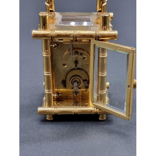 1147 - A small brass simulated bamboo carriage timepiece, height including handle 9.5cm, with winding key.... 