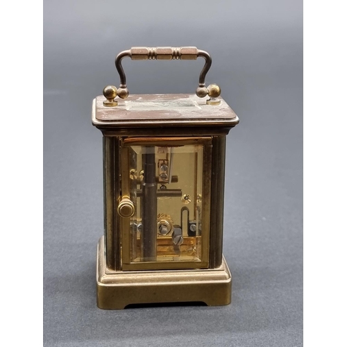 1148 - A miniature brass carriage timepiece, height including handle 10.5cm, with winding key.... 