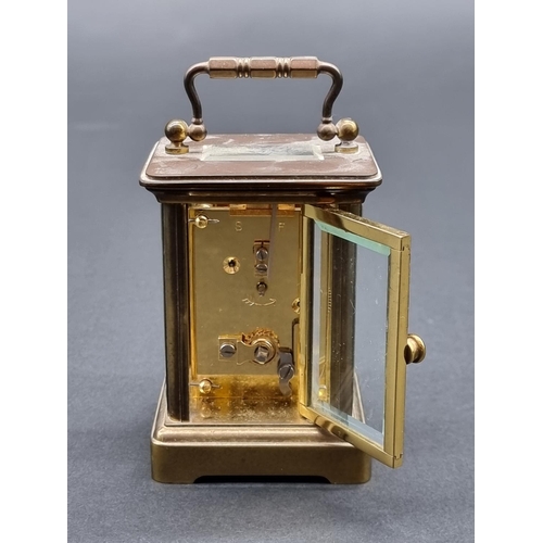 1148 - A miniature brass carriage timepiece, height including handle 10.5cm, with winding key.... 