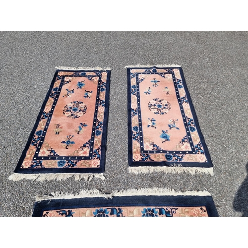 1155A - A Chinese rug, having floral decoration, 190 x 126cm; together with a small pair of Chinese rugs, la... 