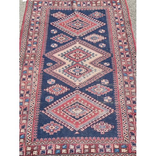 1162 - A Persian rug, having three diamond medallions, with geometric border, 208 x 130cm.