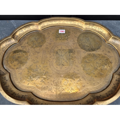 1363 - An Eastern brass tray, 60cm wide; together with a Persian brass plate, 26.5cm diameter; and an ... 