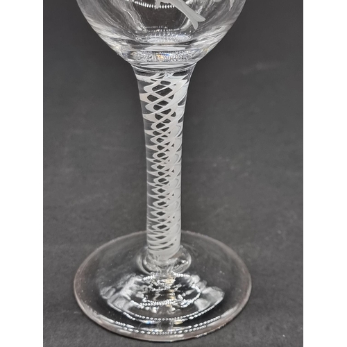 1401 - An 18th century double series opaque twist wine glass, the bowl engraved with a bird and flower... 