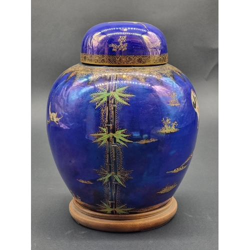 1508 - A Carlton Ware jar and cover, 26cm high, on hardwood stand.