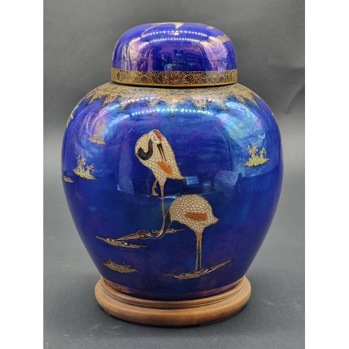 1508 - A Carlton Ware jar and cover, 26cm high, on hardwood stand.