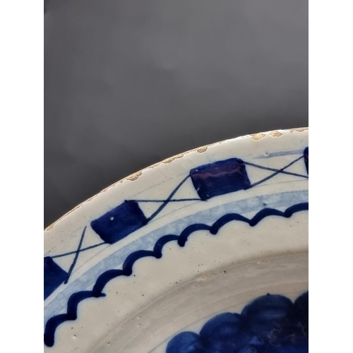 1509 - An 18th century delft blue and white charger, 35.5cm diameter, (rim chips).