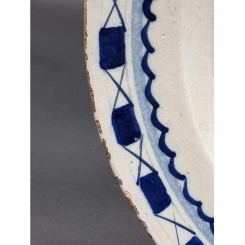 1509 - An 18th century delft blue and white charger, 35.5cm diameter, (rim chips).