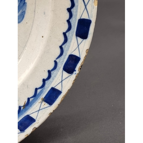 1509 - An 18th century delft blue and white charger, 35.5cm diameter, (rim chips).