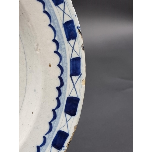 1509 - An 18th century delft blue and white charger, 35.5cm diameter, (rim chips).