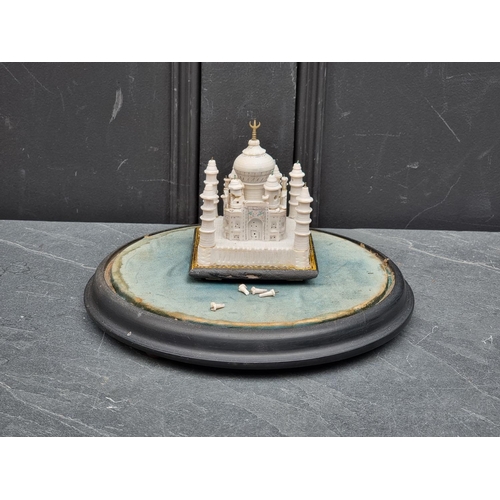 1516 - A Victorian glass dome, 15cm high x 23cm wide, on ebonised stand, enclosing an Indian soapstone... 