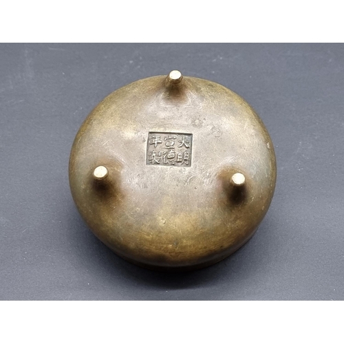 1528 - A Chinese bronze twin handled tripod censer, Xuande six character seal mark to base, 12cm diame... 