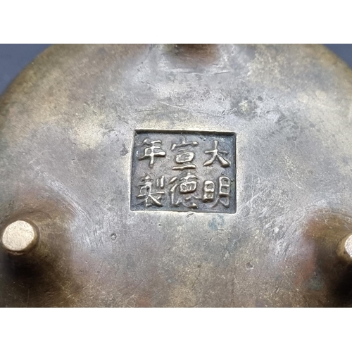 1528 - A Chinese bronze twin handled tripod censer, Xuande six character seal mark to base, 12cm diame... 