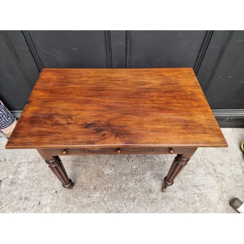 1041 - A 19th century mahogany three drawer side table, on reeded legs, 89.5cm wide.