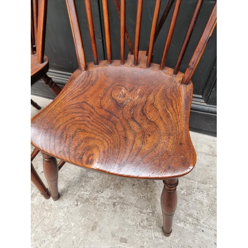 1057 - A near set of four 19th century yew and elm Windsor armchairs, comprising two similar pairs.... 