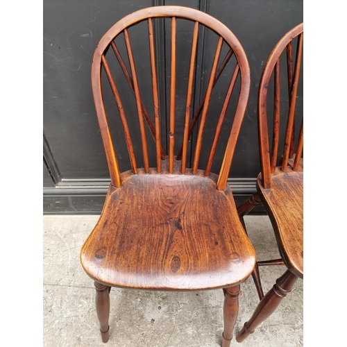 1057 - A near set of four 19th century yew and elm Windsor armchairs, comprising two similar pairs.... 