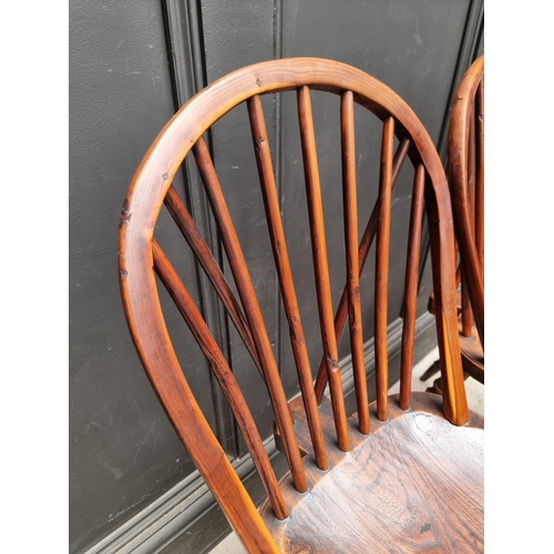 1057 - A near set of four 19th century yew and elm Windsor armchairs, comprising two similar pairs.... 