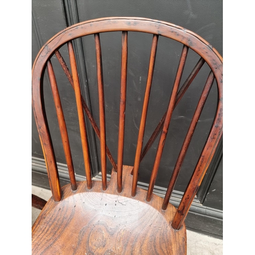 1057 - A near set of four 19th century yew and elm Windsor armchairs, comprising two similar pairs.... 