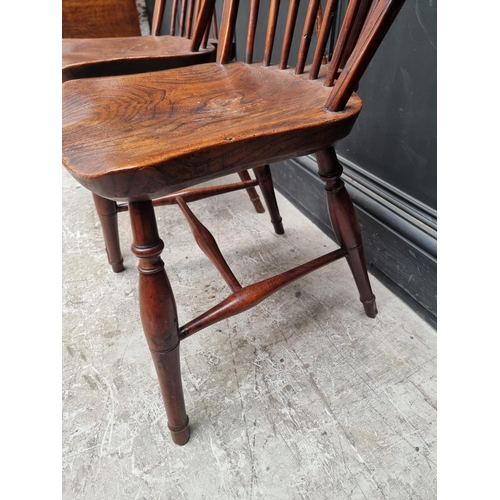 1057 - A near set of four 19th century yew and elm Windsor armchairs, comprising two similar pairs.... 