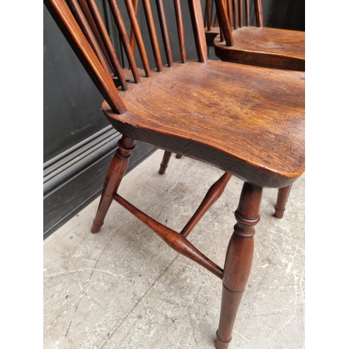 1057 - A near set of four 19th century yew and elm Windsor armchairs, comprising two similar pairs.... 