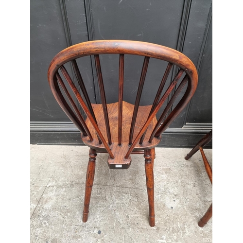 1057 - A near set of four 19th century yew and elm Windsor armchairs, comprising two similar pairs.... 