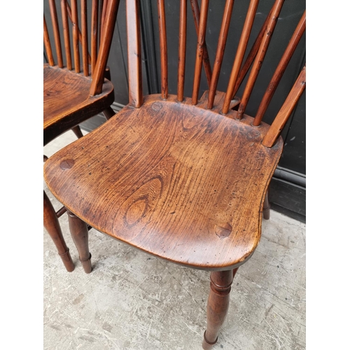 1057 - A near set of four 19th century yew and elm Windsor armchairs, comprising two similar pairs.... 