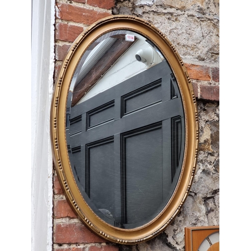 1114 - A gilt framed oval wall mirror, 82 x 57.5cm.