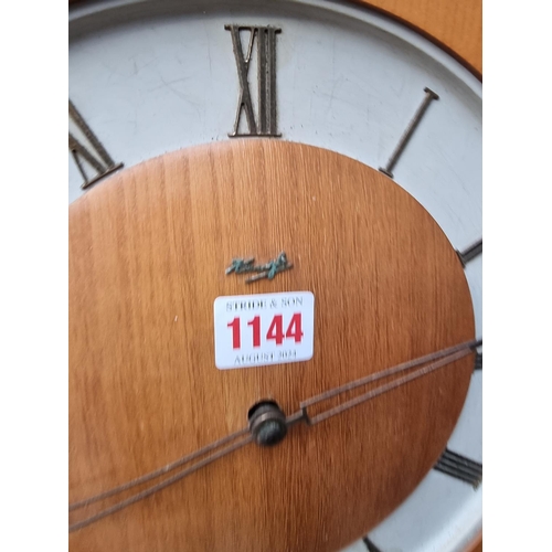 1144 - A 1950s Kienzle wall clock, 28.5cm wide, with weights and pendulum.