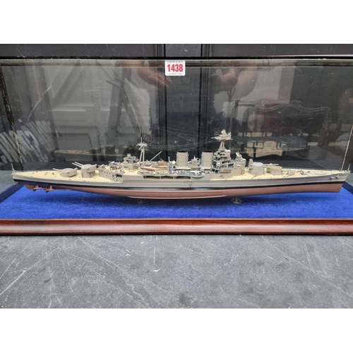 1438 - A painted model of a battleship, in glazed case, 88cm wide.