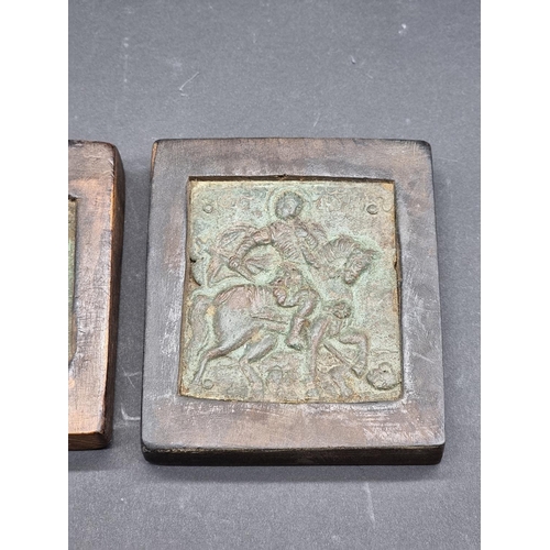 1582 - Two antique small copper alloy Russian icons, each in wood mount, largest 8.5 x 7.5cm.... 