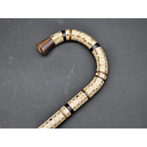 1602 - A horn and vertebrae walking stick, 90cm long.