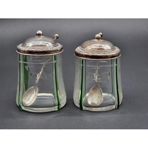 1636 - A pair of silver lidded glass preserve jars, Sheffield 1912, 13cm high, with a pair of matching silv... 