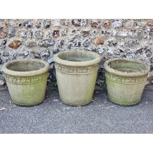 1650 - A garniture of three composition stone garden pots, largest 48.5cm high.