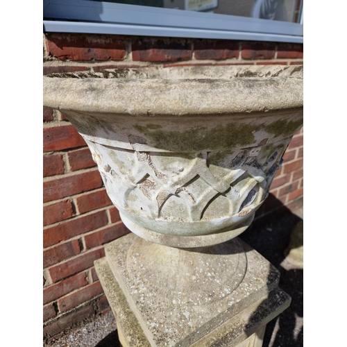 1651 - A composition stone urn and pedestal, 93cm high; together with another similar urn. (2)... 