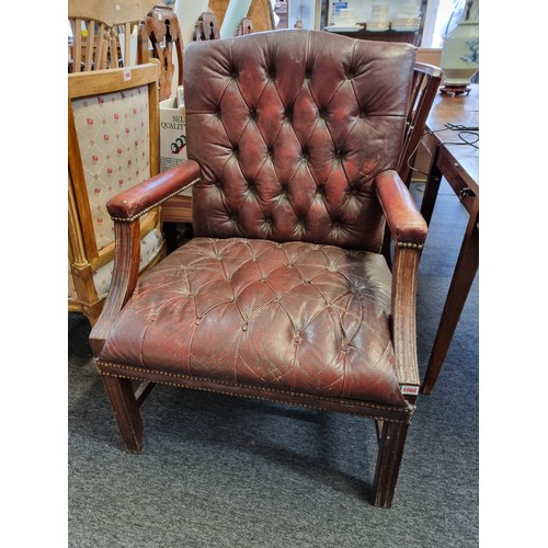 1066 - A mahogany and red buttoned leather Gainsborough chair.