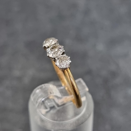 129 - A yellow metal diamond three stone ring, the central stone of approximately 0.15ct, stamped 18ct, si... 