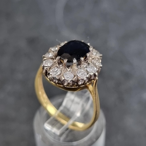 152A - An 18ct gold diamond and sapphire cluster ring, set facetted sapphire surrounded by twelve brilliant... 