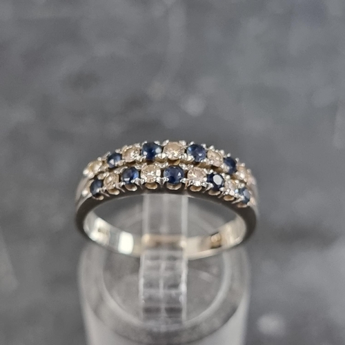 153 - A white metal ring, set two rows of interspersed sapphires and diamonds, size N.