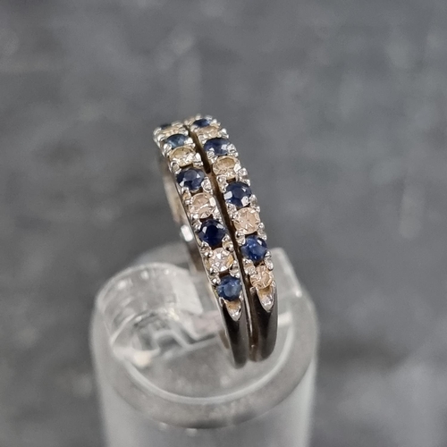 153 - A white metal ring, set two rows of interspersed sapphires and diamonds, size N.