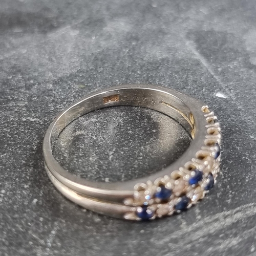 153 - A white metal ring, set two rows of interspersed sapphires and diamonds, size N.