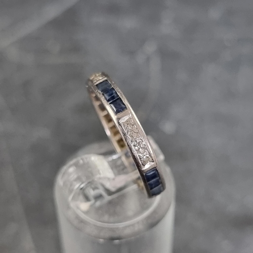 155 - A white metal eternity ring, set twelve calibre sapphires and twelve small diamonds, size N.... 