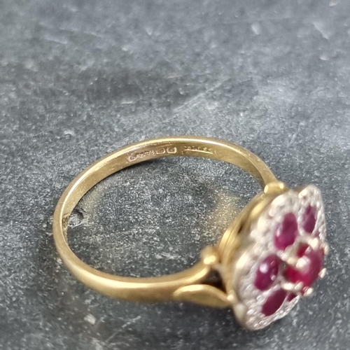 156 - An 18ct gold ruby and diamond floral cluster ring, set seven rubies and multiple small diamonds, siz... 