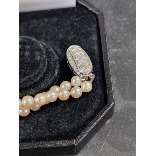 196 - A cased cultured pearl necklace, having clasp stamped 925, approximately 41cm long; together with an... 