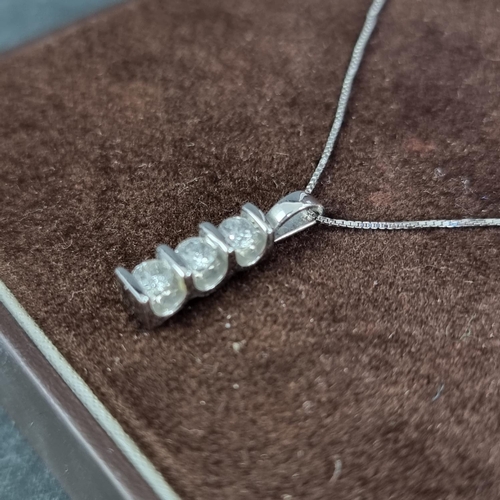 197 - A 9ct white gold pendant, set three brilliant cut diamonds, on a fine box link chain, having clasp s... 